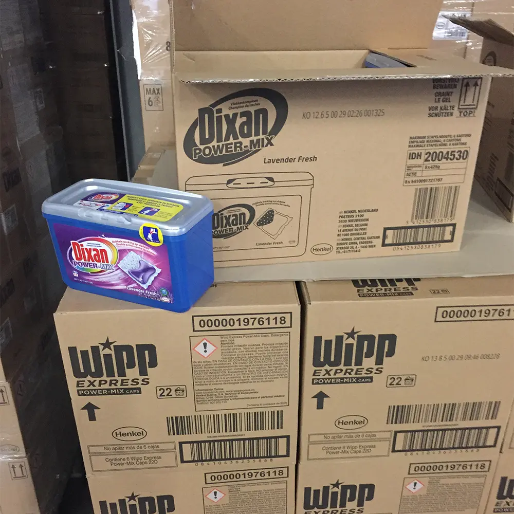 Blue plastic container of Dixan Power-Mix Lavender Fresh detergent placed on stacked Wipp Express Power-Mix Caps cardboard boxes.